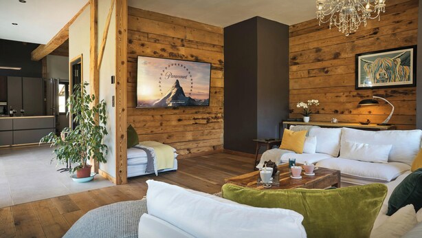 Ein modernes Wohnzimmer mit einem weißen Sofa, einem Holztisch und einer Chandelier.