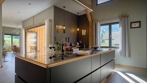 A modern kitchen with a large island, built-in appliances, and a view of the outdoors.