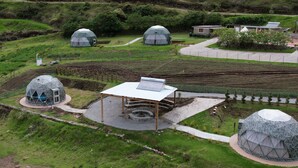 A modern eco-resort with geodesic dome accommodations, a central communal area, and a well-maintained landscape.