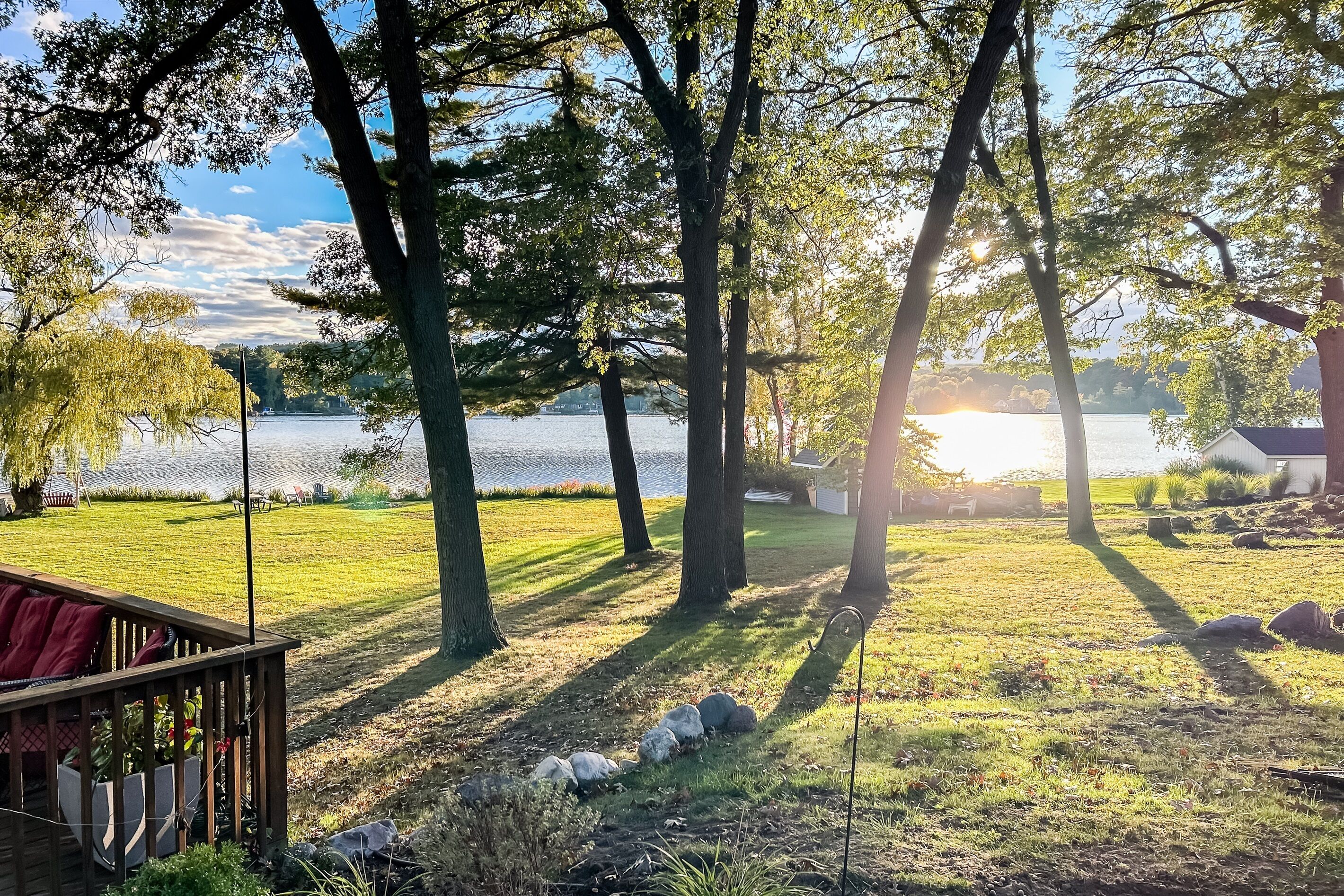 Una propiedad frente al lago con un muelle, árboles y vistas al lago.