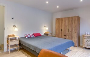 Quarto com uma cama, duas mesas de cabeceira, um guarda-roupa e uma cadeira.