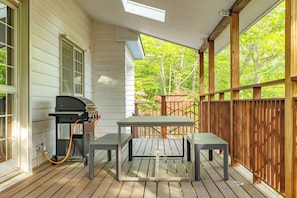 A covered outdoor patio with a grill, a table, and benches. - Nasu Castle Lodge (Nasu-gun)