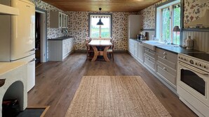 A kitchen with wooden cabinets, a dining table, and a rug. - Lovely home in Furudal with sauna (Furudal)