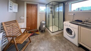 A compact kitchen with a washing machine, a compact refrigerator, and a wooden chair. - Lovely home in Furudal with sauna (Furudal)