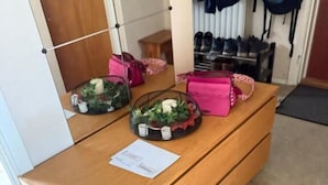 A wooden desk with a small table, a pink bag, and a basket with green plants. - Apartment in S West Sthlm close to Metro (Hägersten)