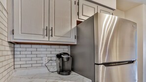 A kitchen with white cabinets, a stainless steel refrigerator, and a coffee maker on the countertop. - Gowen 2411 - 3BR Mid-Term Stay, All Utilities Incl (Wausau)