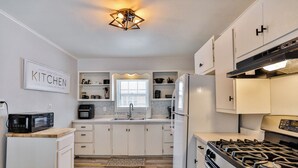 A modern kitchen with white cabinets, a gas stove, a microwave, and a refrigerator. - Gowen 2415 - 2BR Mid-Term Stay, All Utilities Incl (Wausau)