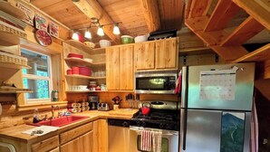 Une cuisine avec des meubles en bois, un réfrigérateur en acier inoxydable, une cuisinière et un four à micro-ondes.