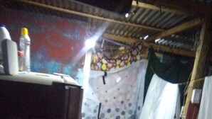 A narrow hallway with a wooden floor, a table with a bottle on it, and a curtain with a polka dot pattern. - Cozy cabin up the hills (Medellín)