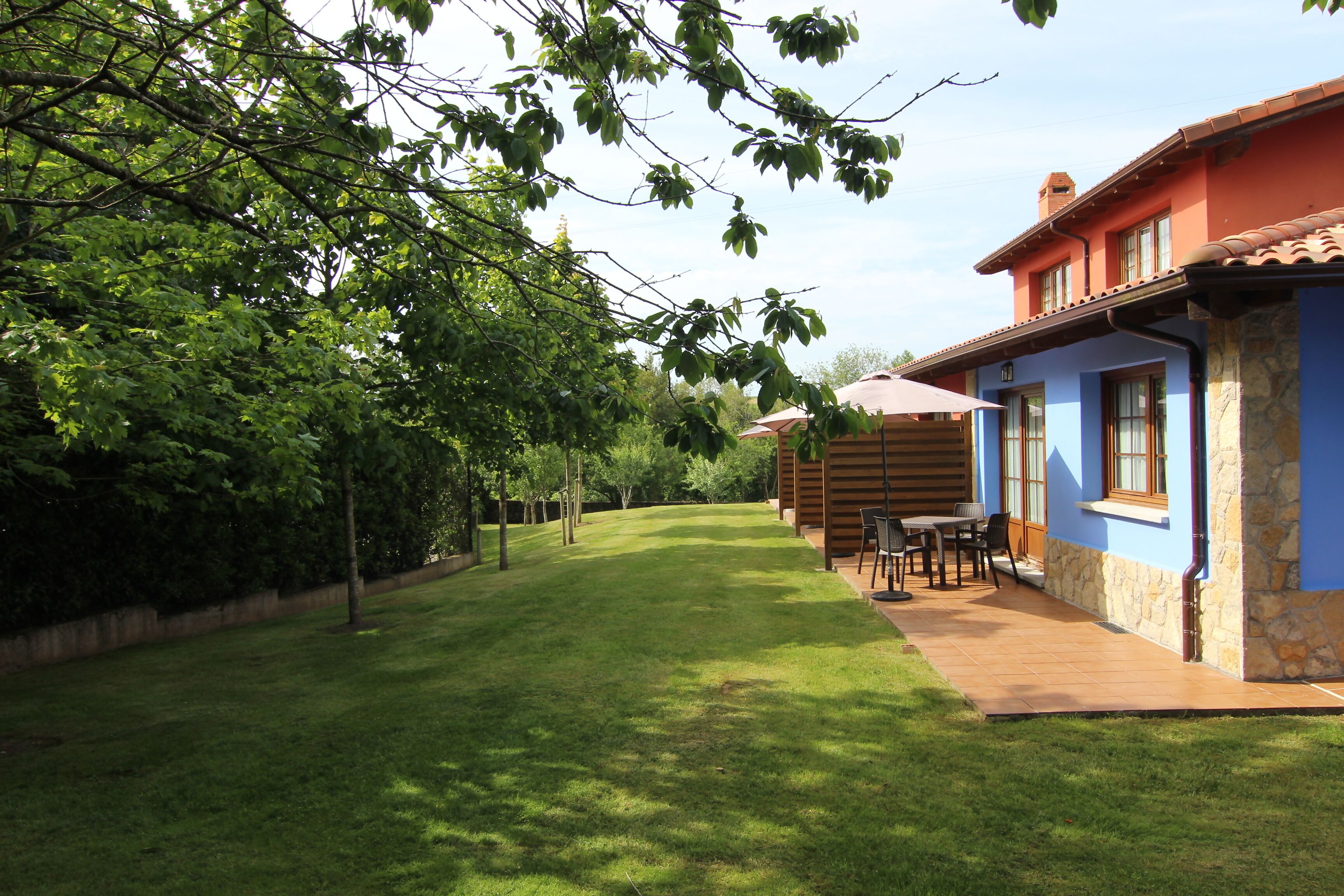 A house with a patio, a lawn, and a tree in the background.