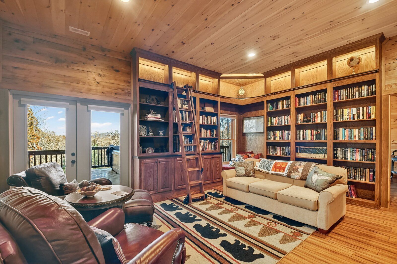 A cozy living room with a fireplace, a large bookshelf, and a comfortable seating area.
