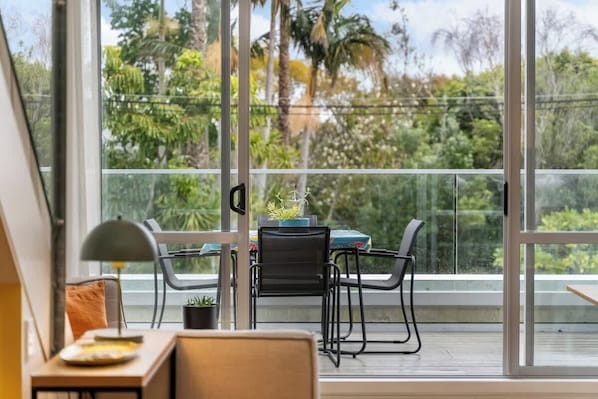 A balcony with a table, chairs, and a potted plant. - Light-Filled Stay, Steps from Ponsonby w Parking! (Auckland City)