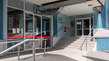 A building entrance with a staircase leading to a door marked '441' and 'Queen Street.'