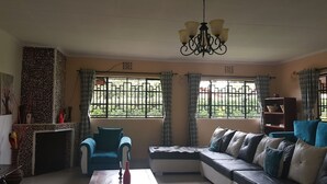 A living room with a sofa, a coffee table, a chair, a bookshelf, and a decorative wall.