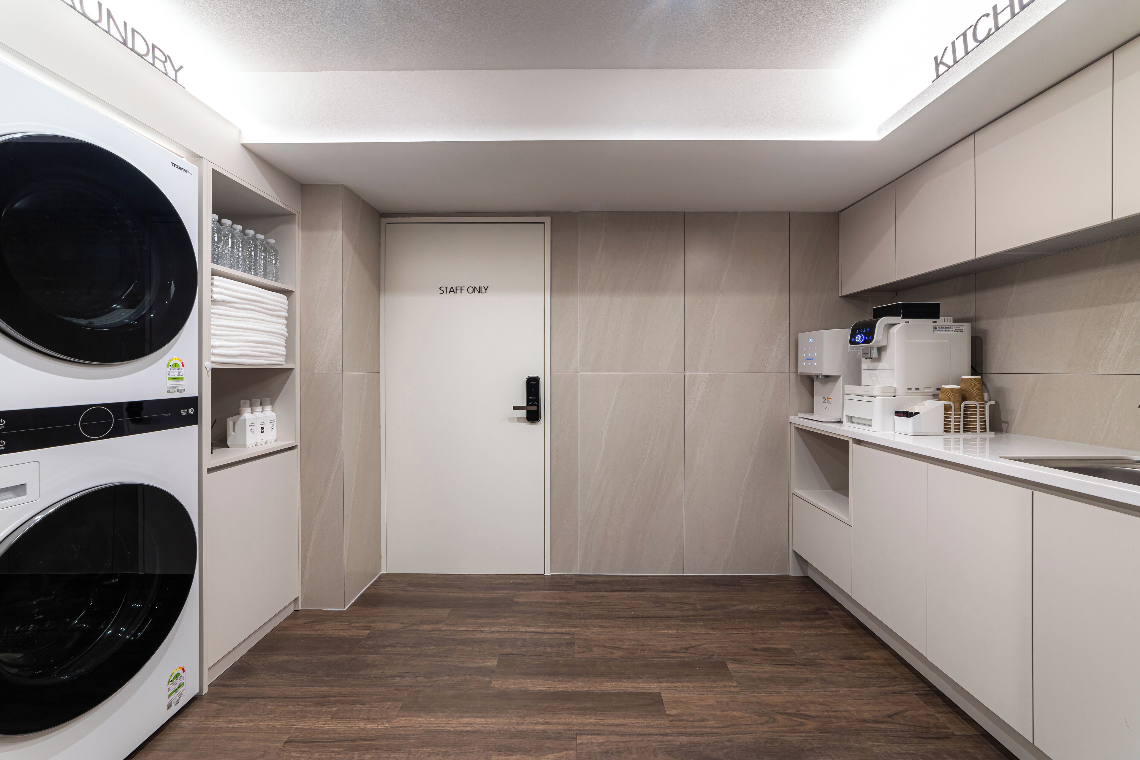 A laundry room with a washing machine, dryer, and a 'STAFF ONLY' door.
