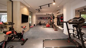A modern home gym with various exercise equipment, including treadmills, an elliptical, and free weights. - 77 by Spacey (#59) | 1BR in Maadi (Maadi)