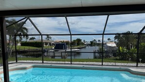 Ein Swimmingpool mit Blick auf einen Hafen und Palmen.