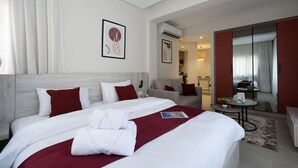 Ein Hotelzimmer mit einem großen Bett, einer Couch, einem kleinen Tisch und einem Spiegel.