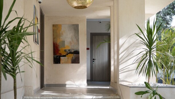 Una scalinata in marmo che conduce a una porta, con un lampadario appeso sopra.
