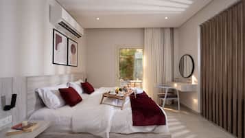 Une chambre d’hôtel moderne, dotée d’un grand lit, d’un bureau, d’une chaise et offrant une vue sur la verdure environnante.