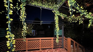 A wooden deck with a lattice railing and hanging vines. - Luxury sweet home (Longueuil)