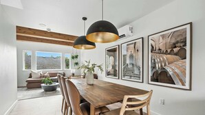 A dining area with a wooden table, chairs, pendant lights, and framed pictures on the wall. - 5BR at The Adelynn - Luxury Build - Walk to All (Portland)