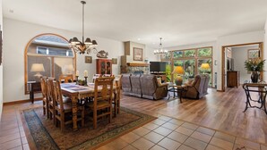 A spacious living area with a dining table, sofas, and a fireplace.