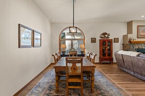 A dining room with a wooden table, chairs, and a rug.