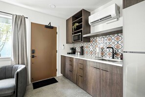 Een koffiezetapparaat/waterkoker, kookgerei, borden en bestek