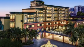 A multi-story hotel with a central courtyard, a fountain, and a well-lit entrance. - UrCove by HYATT Zhuhai Gongbei Port (Zhuhai)