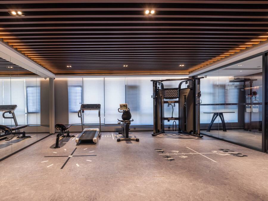 A modern gym with treadmills, stationary bikes, and a weightlifting area.