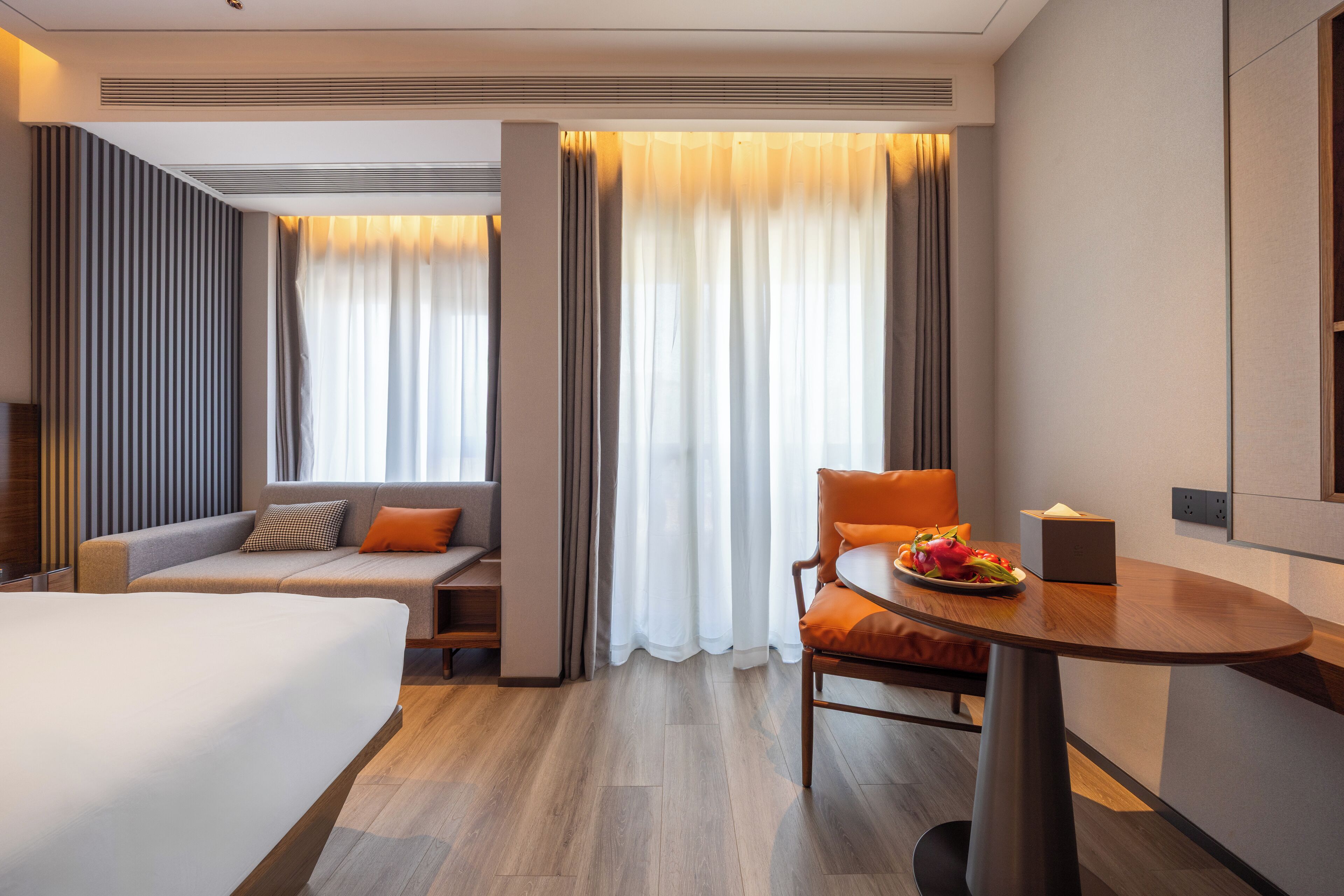 Una habitación de hotel con una cama, un sofá, una mesa de comedor y una silla.