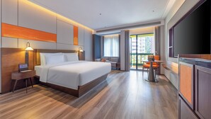 A modern hotel room with a large bed, bedside tables, a desk, and a view of the city. - UrCove by HYATT Zhuhai Gongbei Port (Zhuhai)