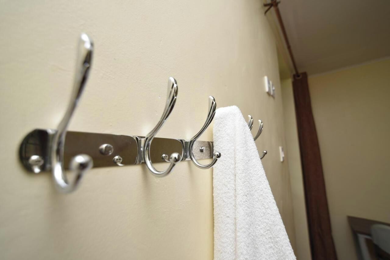 A metal towel rack with a white towel hanging on it.