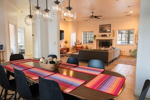 Un espace repas comprenant une longue table, des chaises et un lustre.