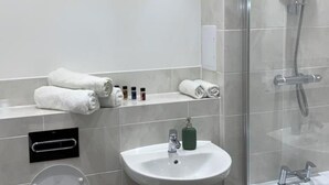 Een moderne badkamer met toilet, wastafel en douche.