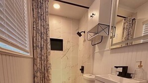 Un bagno moderno con toilette, lavandino e zona doccia.