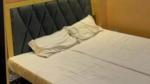 Ein Schlafzimmer mit Bett, Kopfstütze und Deckenleuchte.