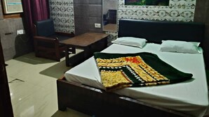 Habitación de hotel con cama, escritorio, silla y un cuadro en la pared.