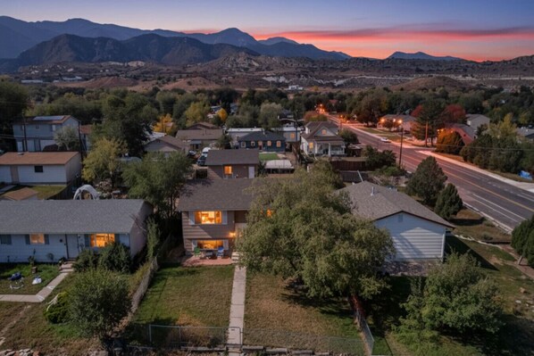 A residential area with houses, a road, and mountains in the background.