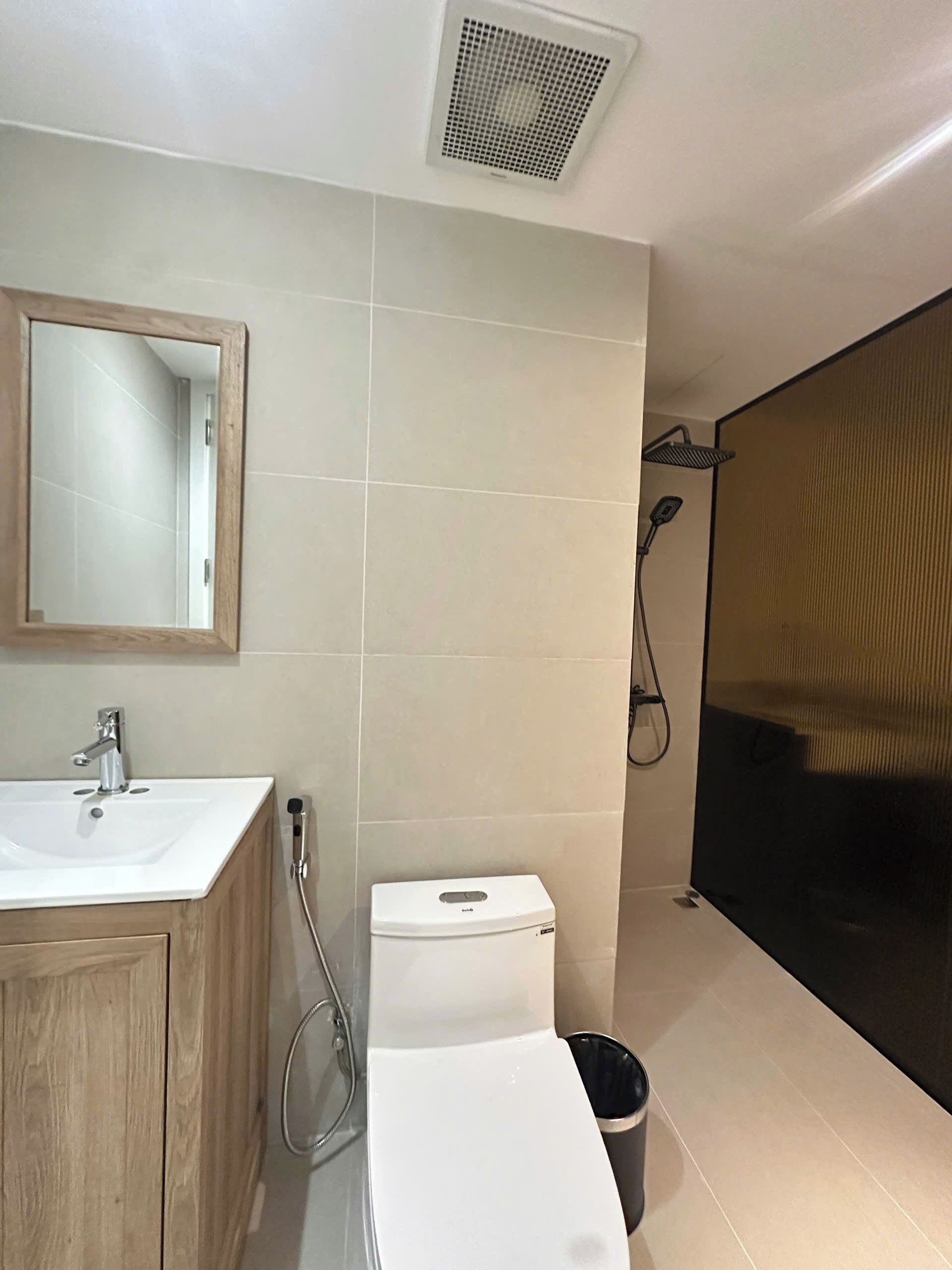 Une salle de bain avec un lavabo blanc, un miroir et des toilettes.