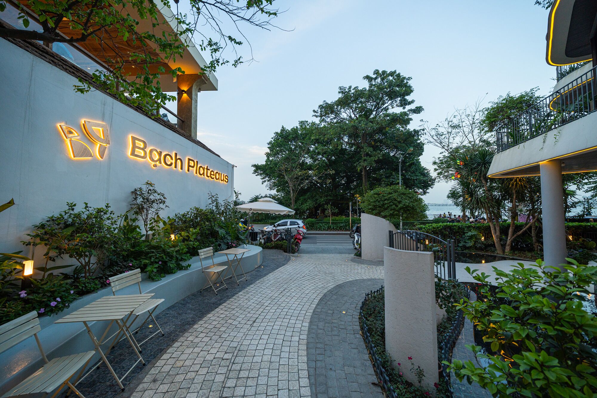 Un restaurante llamado 'Bach Plateaus' con terraza y vistas al agua.