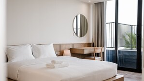 A modern hotel room with a large bed, a wooden desk, a mirror, and a view of the outdoors. - Bach Plateaus Hotel (Hanoi)