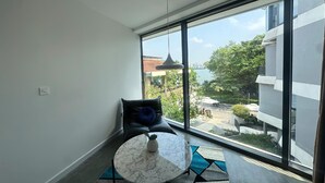 A modern room with a large window, a round marble table, and a black leather chair. - Bach Plateaus Hotel (Hanoi)