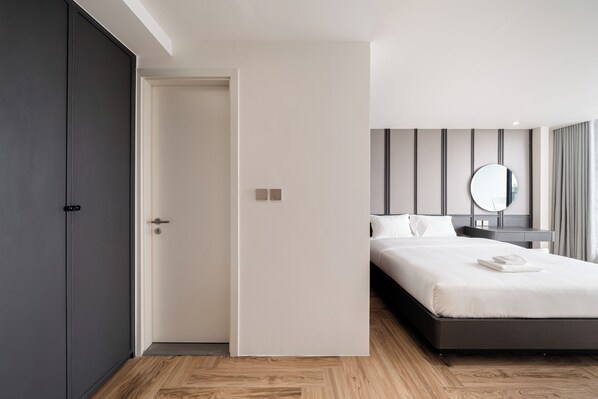 A modern hotel room with a large bed, a bedside table, a mirror, and a wardrobe. - Bach Plateaus Hotel (Hanoi)