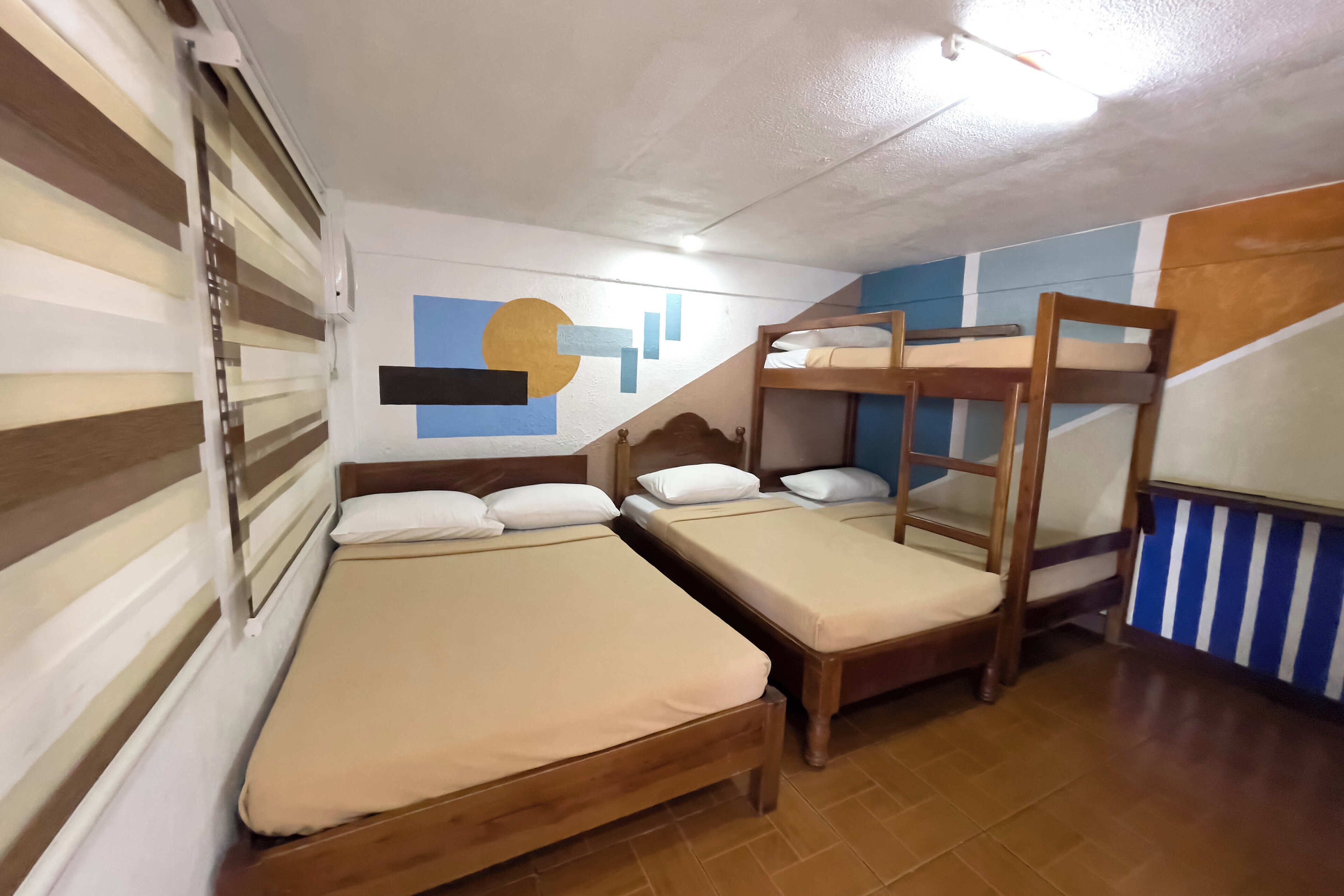 A dormitory room with bunk beds and a single bed.