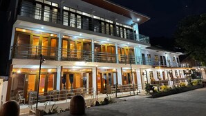 A two-story hotel with a balcony on the upper floor, outdoor seating, and a well-lit entrance. - Sebay Surf Central San Juan La Union (San Juan)