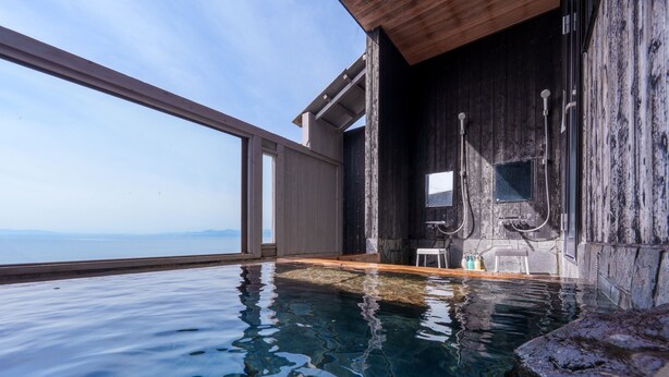 A clear pool with a wooden deck, a small seating area, and a view of the sea. - costadelsol-hiji (Hiji)