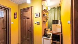 A compact kitchen with a microwave, a small refrigerator, and a sink.