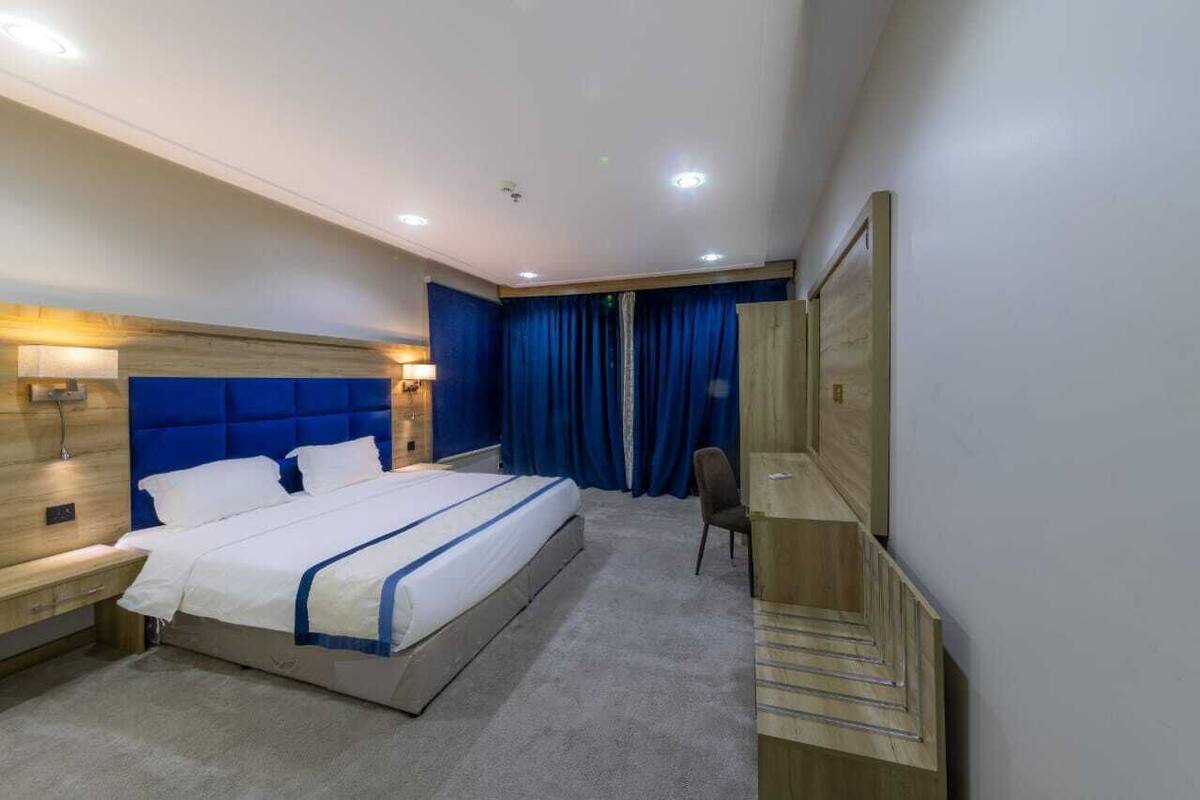 Ein modernes Hotelzimmer mit einem großen Bett, einem Schreibtisch und einem Stuhl.